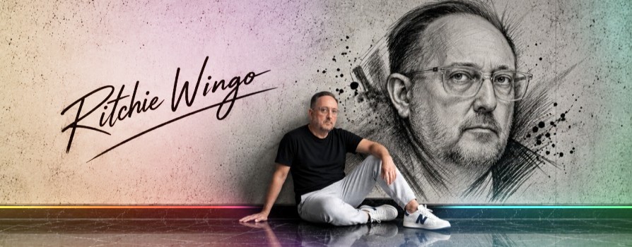 Ritchie Wingo seated on a marble floor beneath his signature and a large charcoal portrait of himself, the wall washed in the series colours